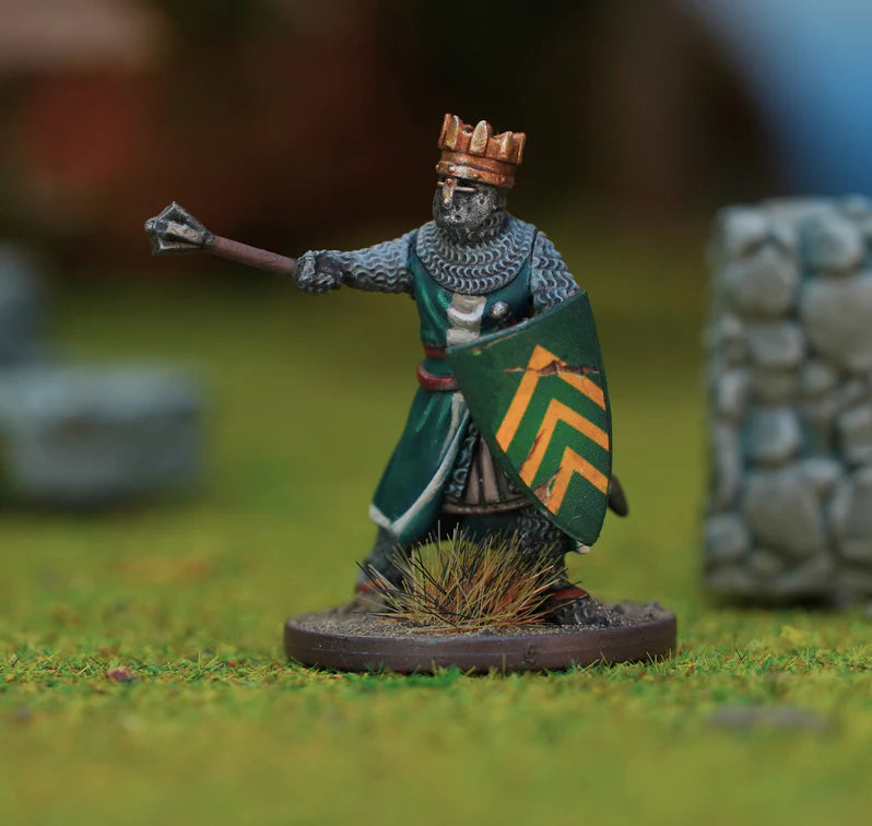 Miniature figure of a king with a crown, shield, and spear on a grassy field