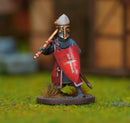Miniature figurine of a warrior with a shield and spear on a grassy surface