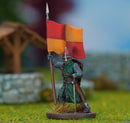 Miniature figure of a warrior holding a red and orange flag on a grassy field with blurred background