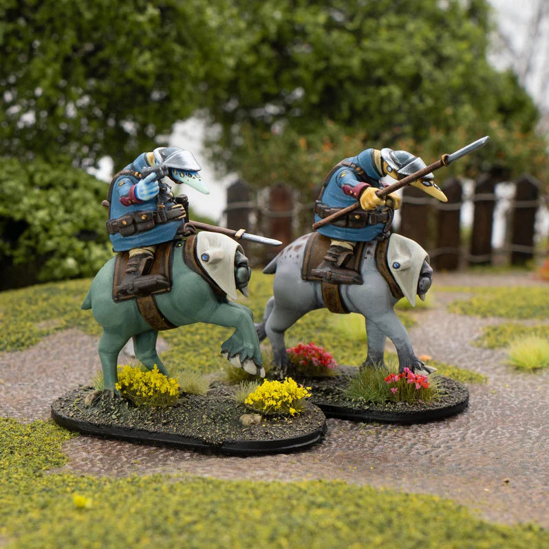 Two miniature figures on horseback with blue armor and spears, set against a natural background.