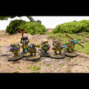 Miniature figures in a natural setting with greenery and dirt ground.