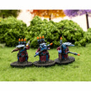 Three miniature figures with futuristic weapons on grass with blurred foliage in the background