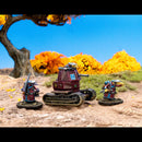 Model tank with two figures in a desert landscape with trees and blue sky.