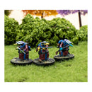 Three miniature figures on grass with a blurred natural background
