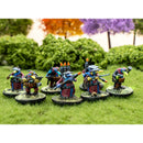 Miniature figures on round bases in a grassy area with trees in the background