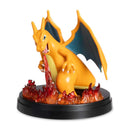 Dragon-like creature figurine with fiery breath on a white background