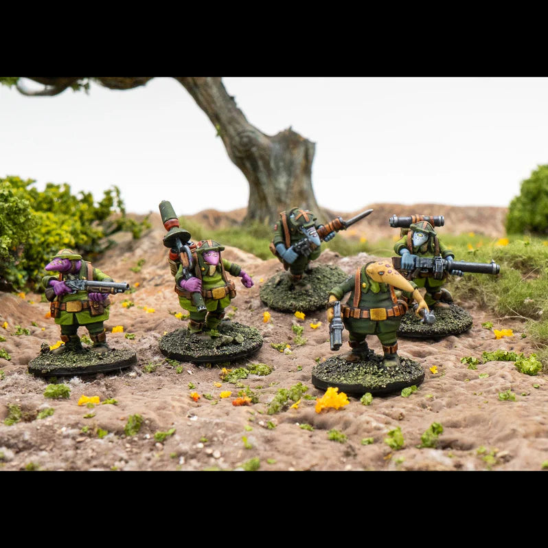 Five miniature figures in a natural setting with trees and grass.