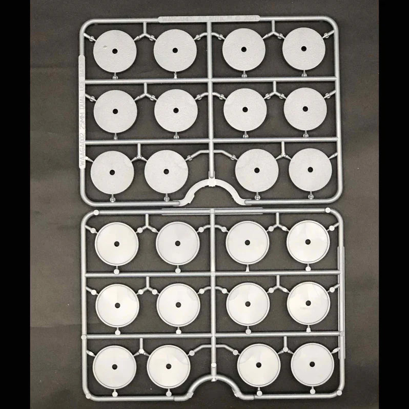 Two trays with white circular components on a dark background