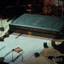 Game box titled 'Candela Obscura' with dice and gaming sheets on a table, featuring the Darrington Press logo.