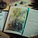 Open book with fantasy illustration and text on a table with gaming components