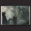 Open book showing a fantasy scene with a castle and dragon silhouette.