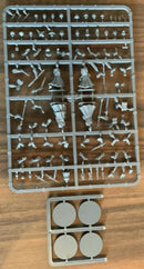 Plastic model parts on a tray with small round components on a wooden surface