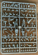 Plastic model kit with various small parts on a wooden surface