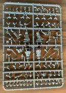 Plastic model parts on a tray with various small figures and accessories on a wooden surface