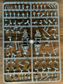 Collection of small figurines on a plastic sheet against a wooden background