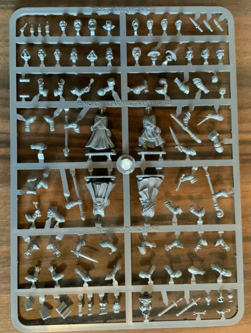 Collection of small figurines on a plastic sheet against a wooden background