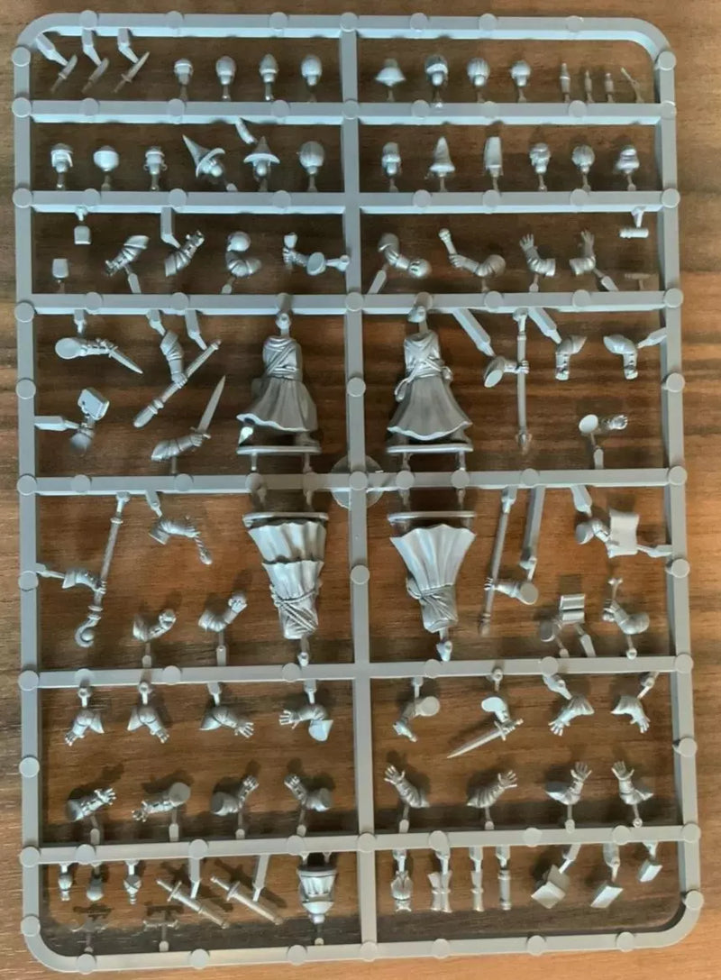 Plastic figurine parts on a tray with a wooden background