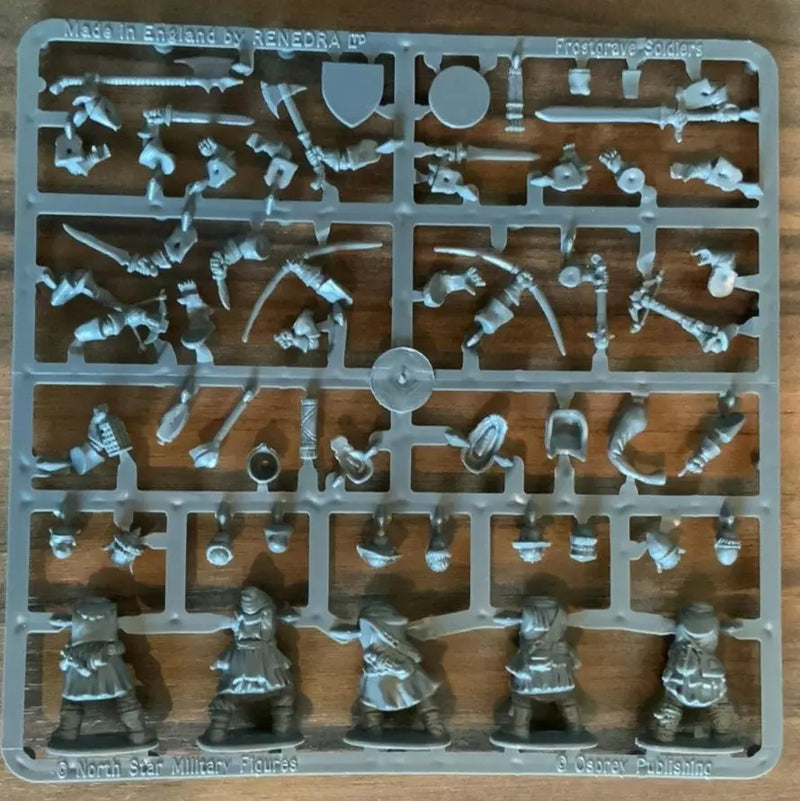 Plastic mold with miniature figures and accessories on a wooden surface